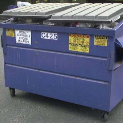Blue dumpster full of trash