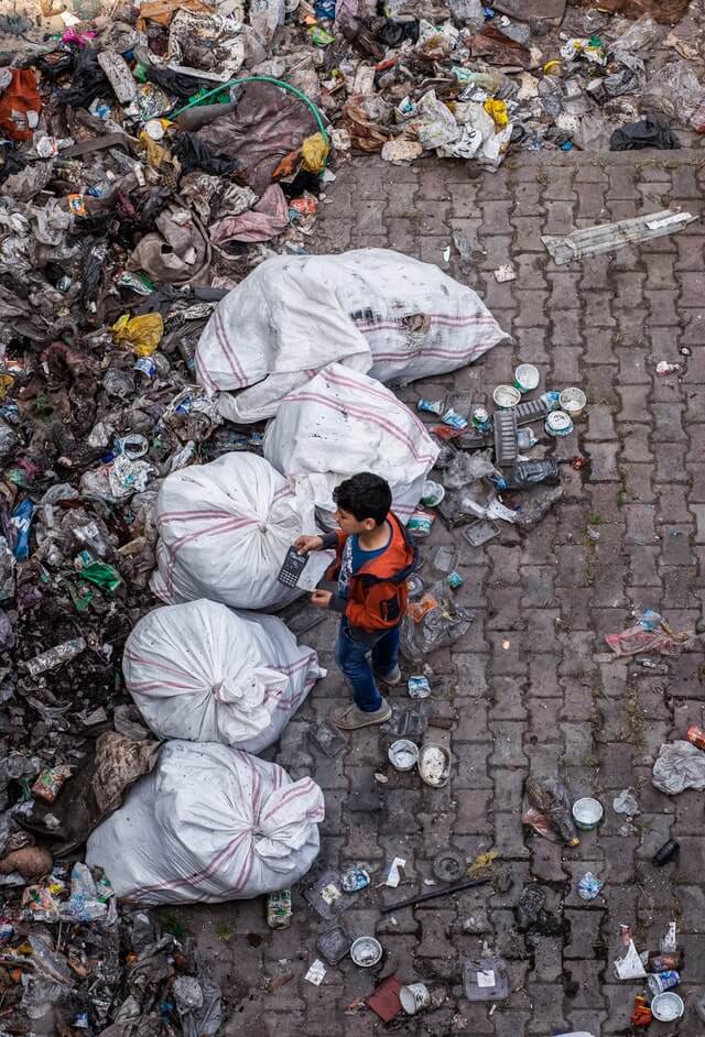 child-standing-near-garbage
